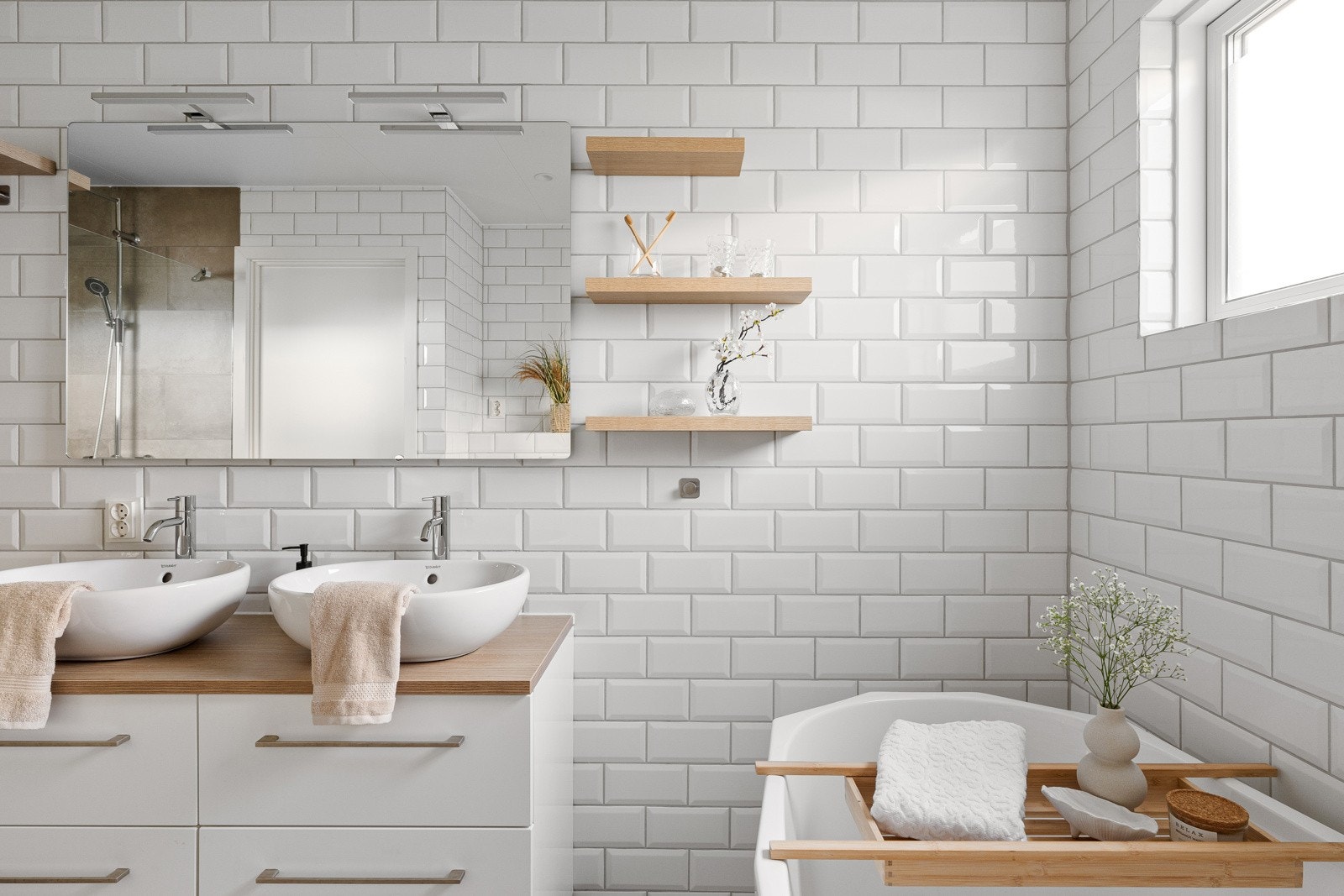 Rommet har flislagte overflater, dusjhjørne, frittstående badekar, vegghengt toalett, servantmøbel og varmekabler i gulv. Galleribilde