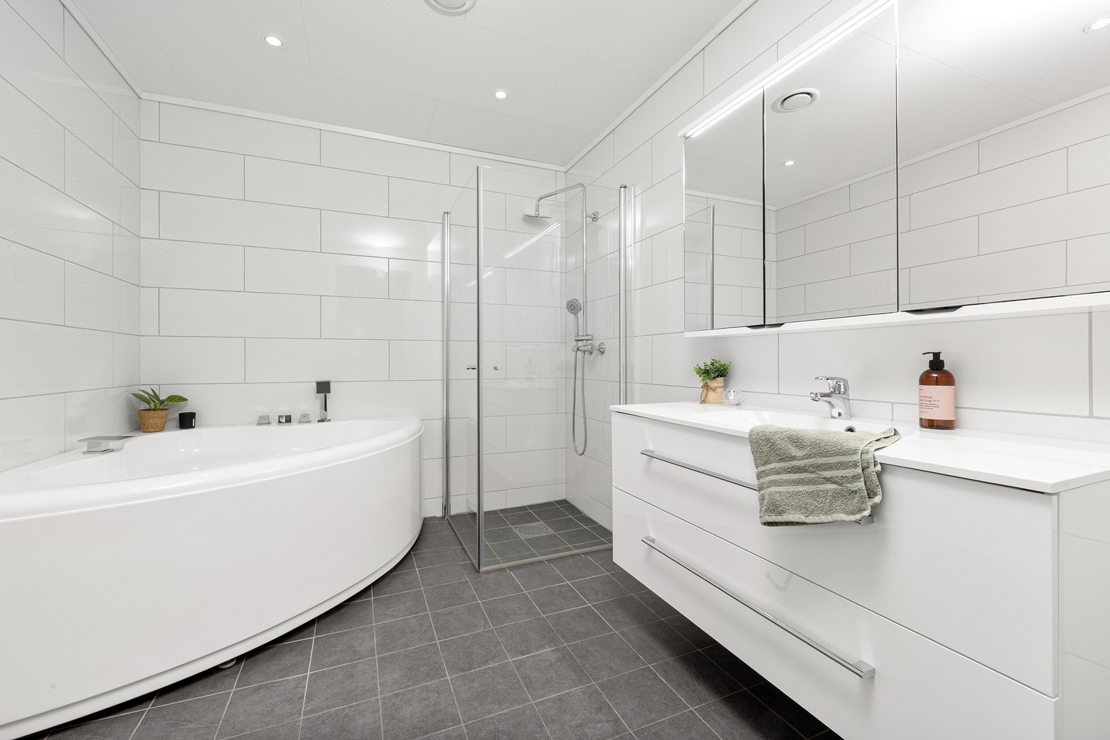 Badet i 1. etasje har innredning med nedfelt servant, vegghengt toalett, badekar og dusjhjørne. Galleribilde