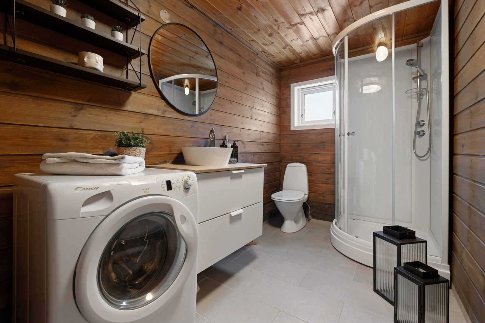 Badet har flislagt gulv med elektriske varmekabler, panel på vegger og i tak, samt opplegg for vaskemaskin. Galleribilde