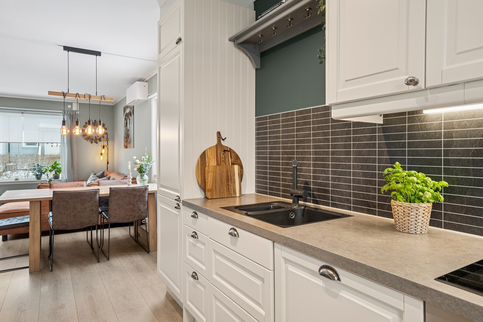 Det er montert kjøkkenplater mellom benk og overskap. Galleribilde