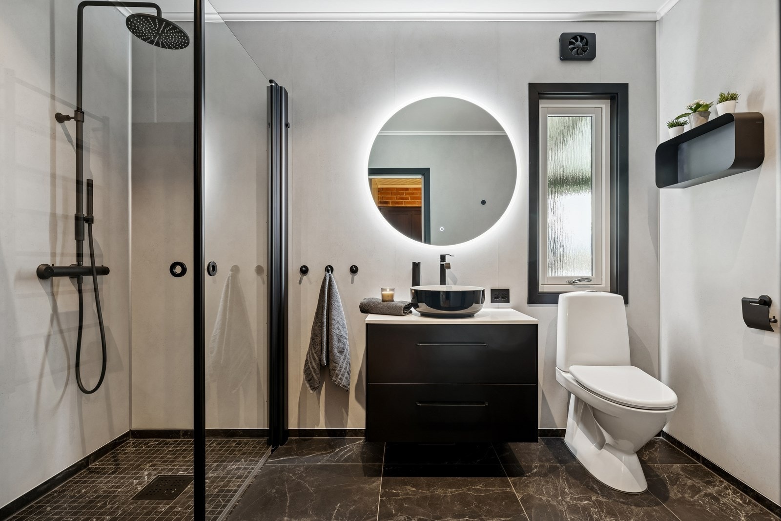 Stilig bad med behagelig gulvvarme, og dusjhjørnet har praktiske, innfellbare dører. Galleribilde