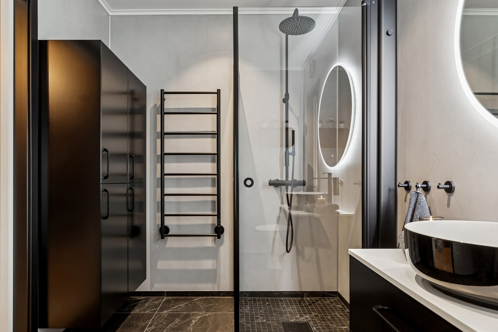 To høyskap gir rikelig med oppbevaringsplass, og en elektrisk håndkletørker gir ekstra komfort. Galleribilde