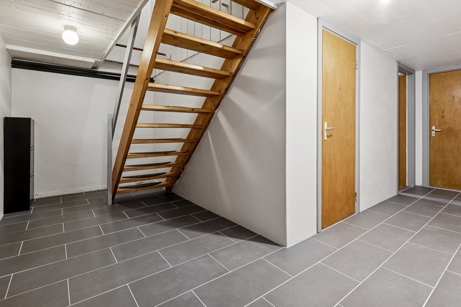 Tretrappen leder ned til kjelleretasjen, som inneholder boder og vaskerom. Galleribilde