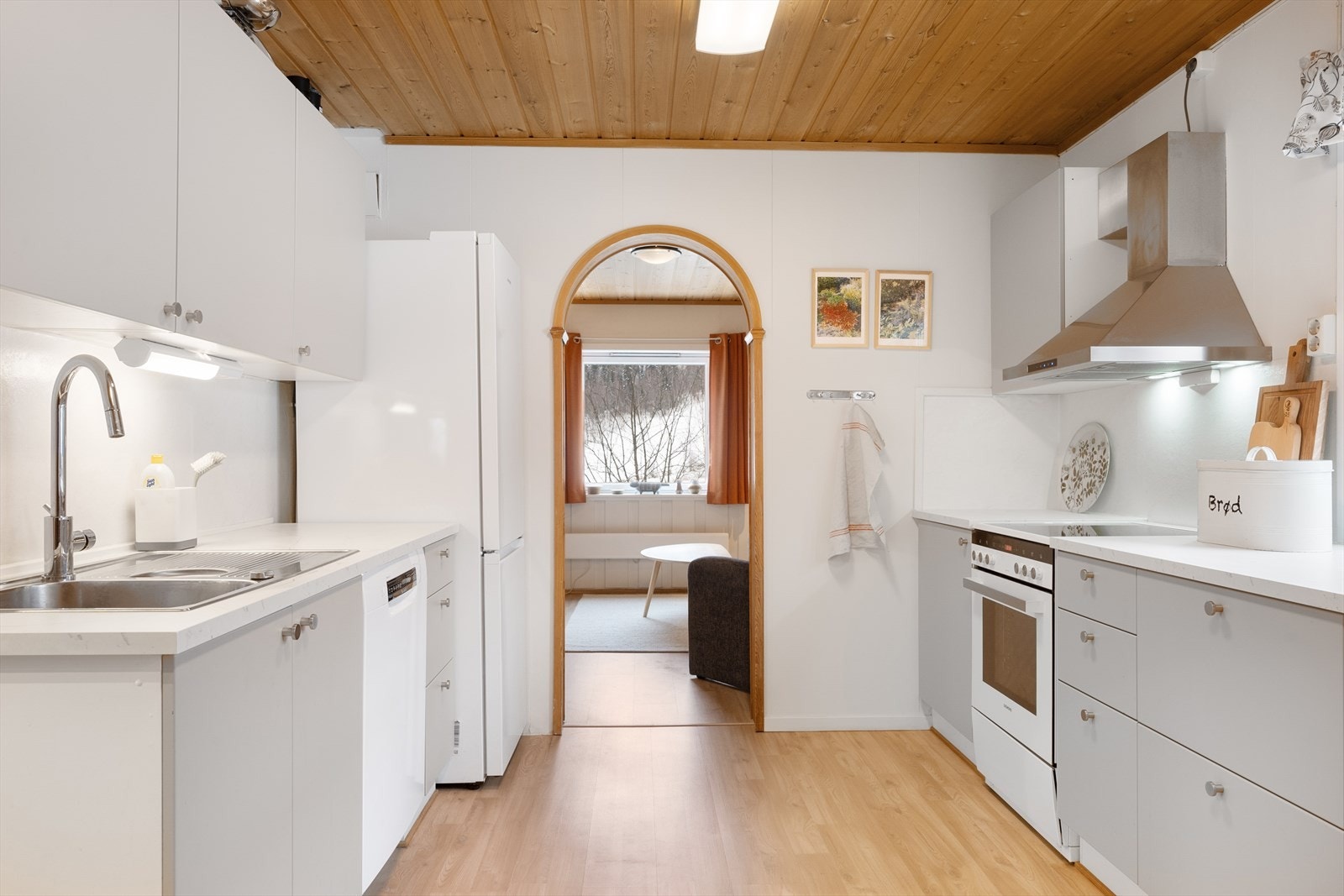 Innredningen har slette fronter og benkeplate i laminat, og frittstående hvitevarer. Galleribilde