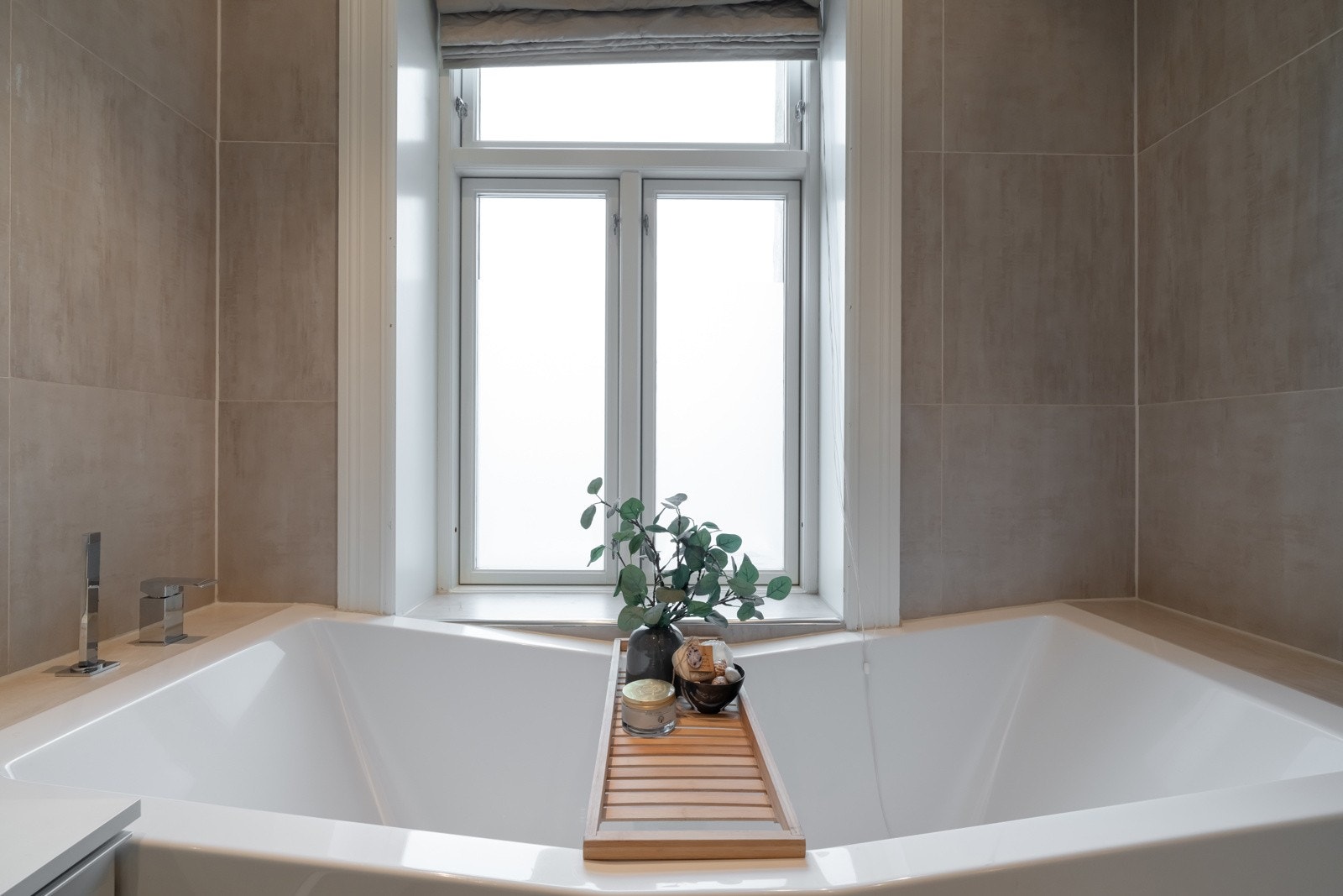 Hovedbadet innredet med vegghengt servantinnredning med to servanter og skuffer under. Innmurt badekar, dusjhjørne og vegghengt toalett. Galleribilde