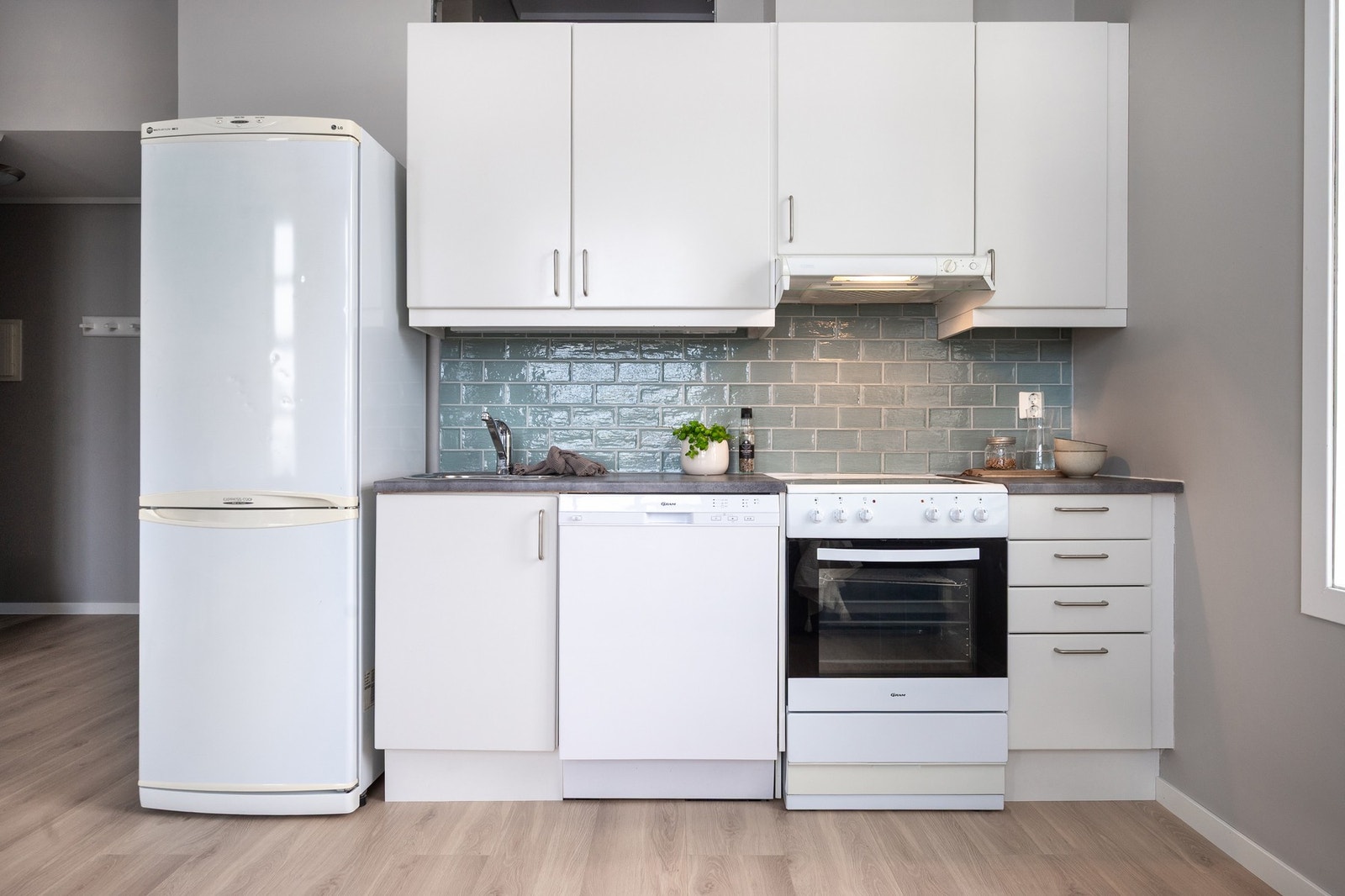 Hvitt kjøkken med frittstående hvitevare. Galleribilde