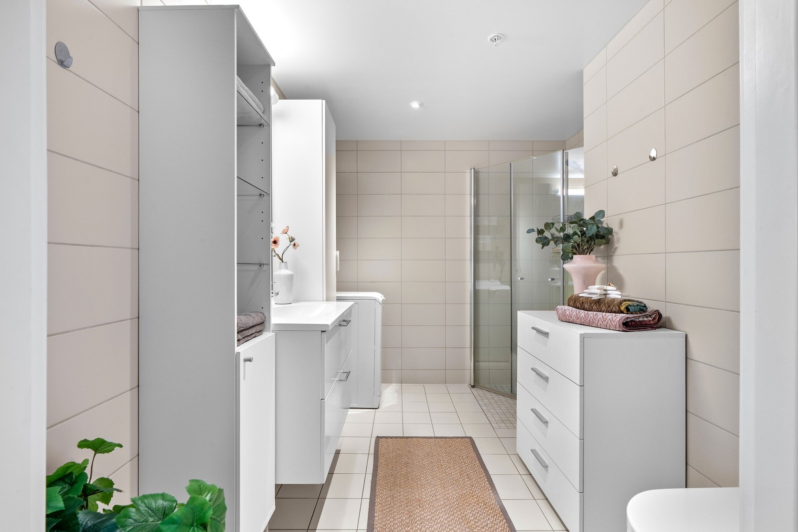 Moderne, flislagt bad med et stilrent flisvalg og varmekabler. Galleribilde