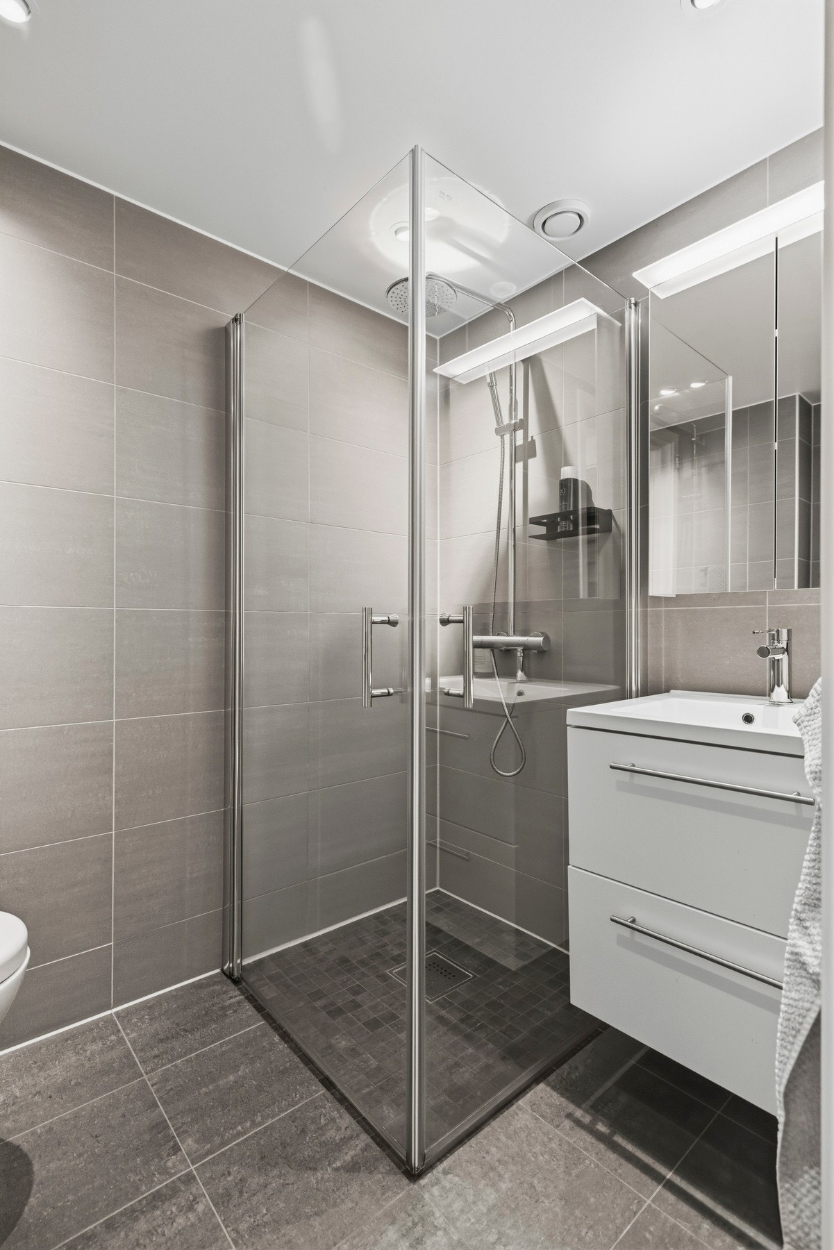 Badet i underetasjen har flislagte gulv og vegger, slette overflater i himlingen og vannbåren gulvvarme Galleribilde