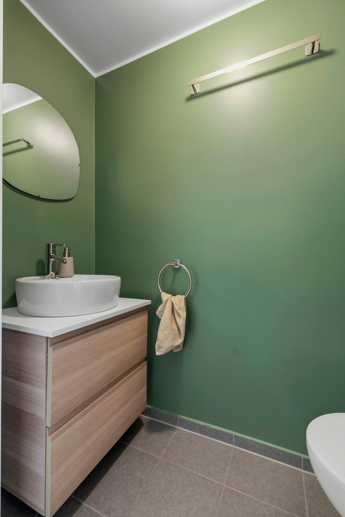 Toalettrommet i 1.etasje har flislagt gulv, vannbåren gulvvarme, vegghengt klosett med innebygget sisterne og innredning med slette fronter Galleribilde