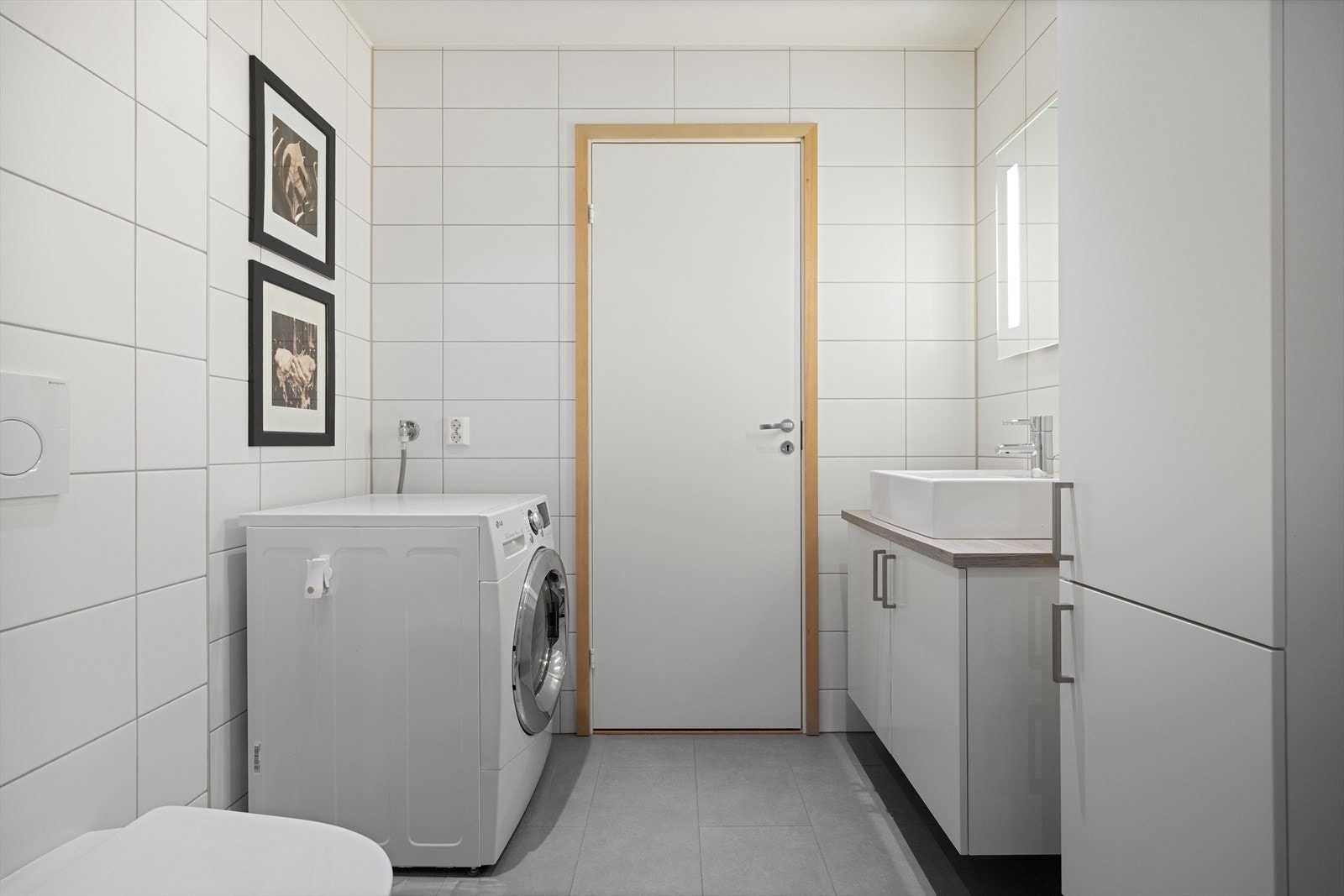 Vegger og gulv er flislagt i nøytrale fargetoner, og himlingen er malt med downlights som gir jevn og behagelig belysning. Galleribilde