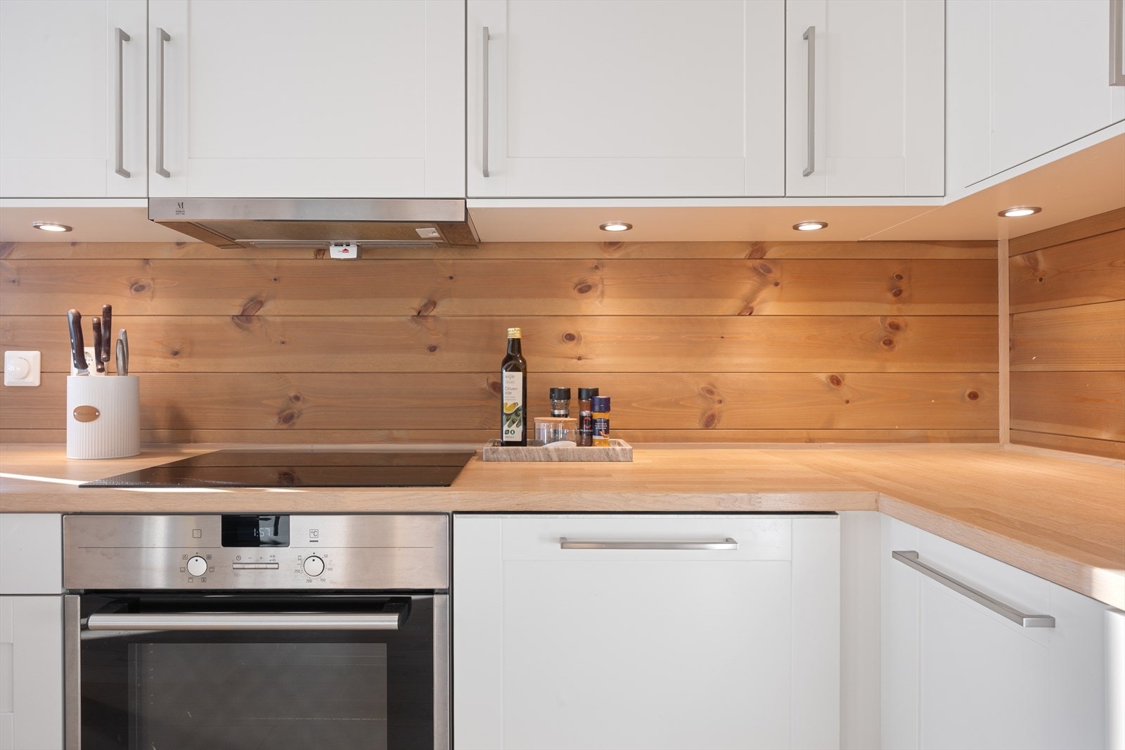 Innredningen har glatte, hvite fronter som gir et tidløst og stilrent uttrykk, kombinert med en heltre benkeplate som tilfører varme og karakter. Galleribilde