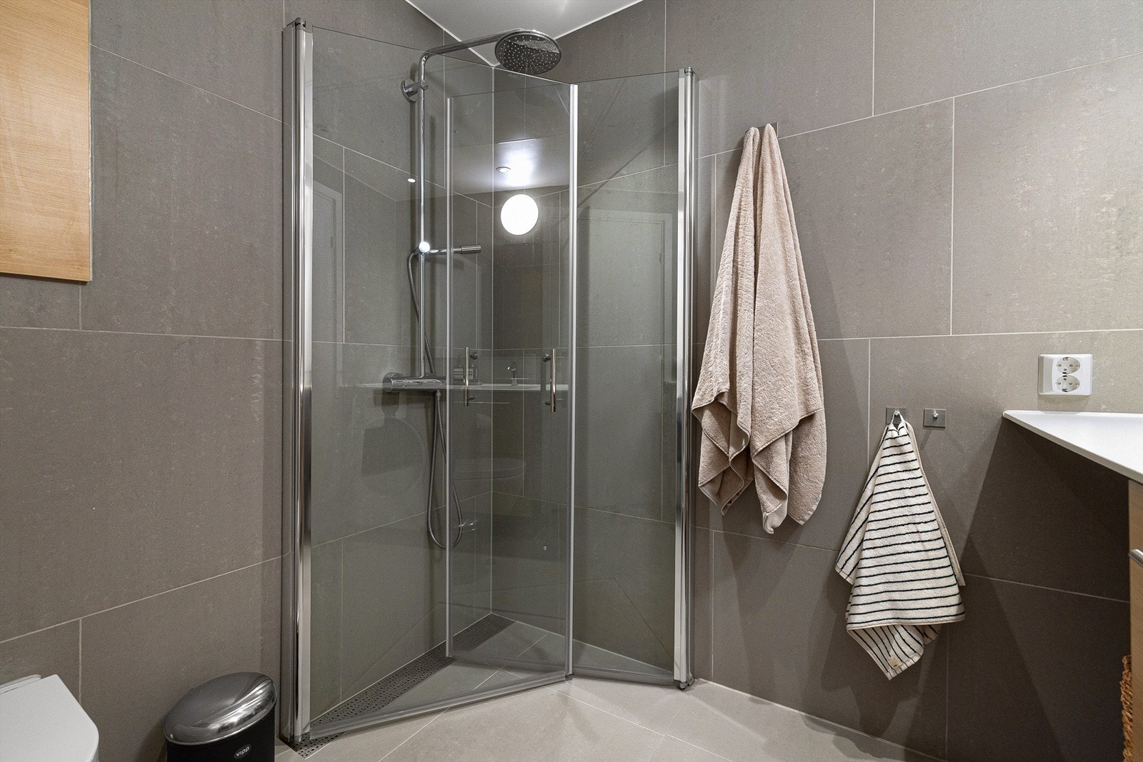 Regnfallsdusj og svingbare dusjdører som er plassbesparende. Gulvvarme og downlights med dimmefunksjon. Opplegg for vaskemaskin/tørketrommel under benkeplate. Galleribilde