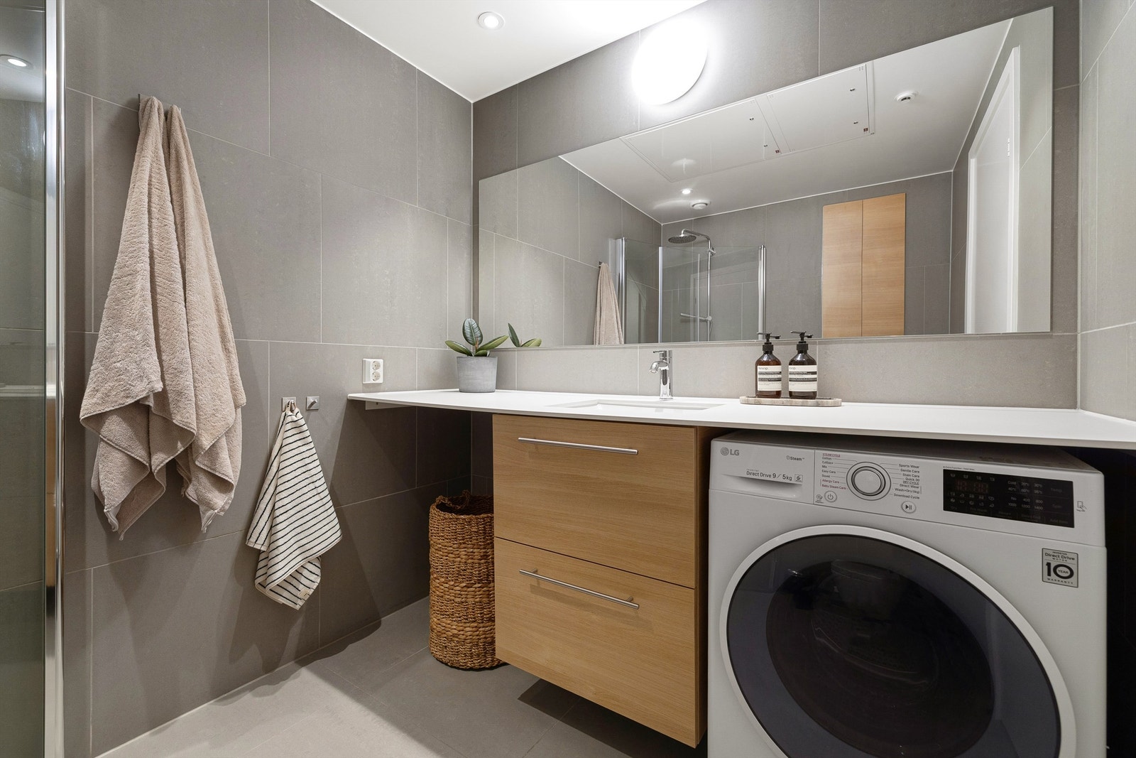 På badet starter du dagen i innbydende omgivelser. Det er store fliser i 60x60cm, heldekkende benkeplate med servant, skapinnredning og stort speil. Galleribilde