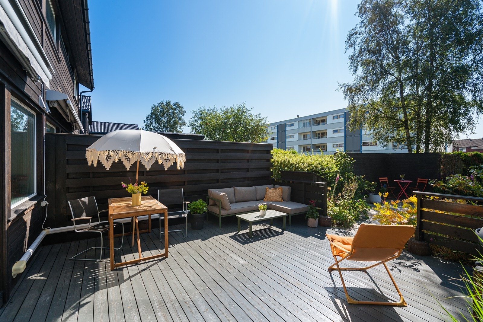 Boligen har en solrik terrasse og hage med plass til flere sittegrupper Galleribilde