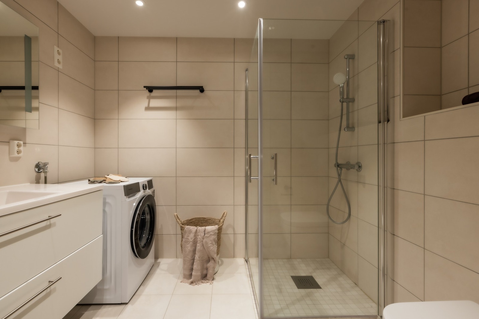 Delikat baderom med gulvvarme og opplegg for vaskemaskin og tørketrommel Galleribilde