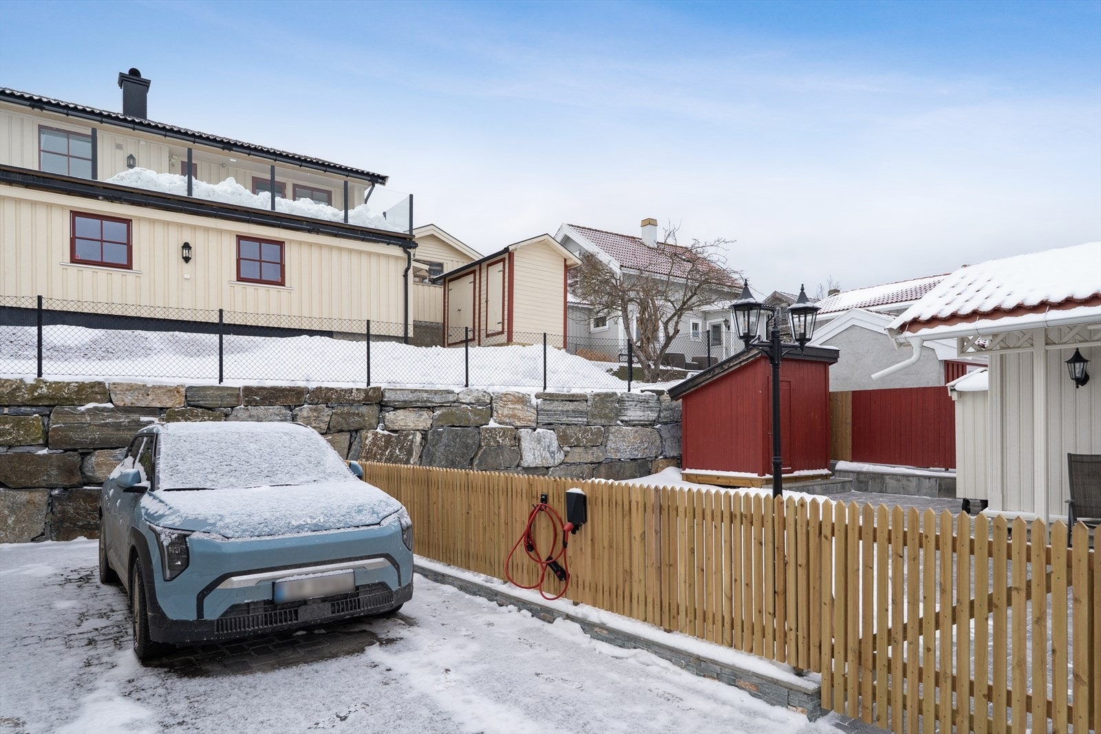 Parkeringsplass for 2 biler. Elbil lader montert på gjerde Galleribilde