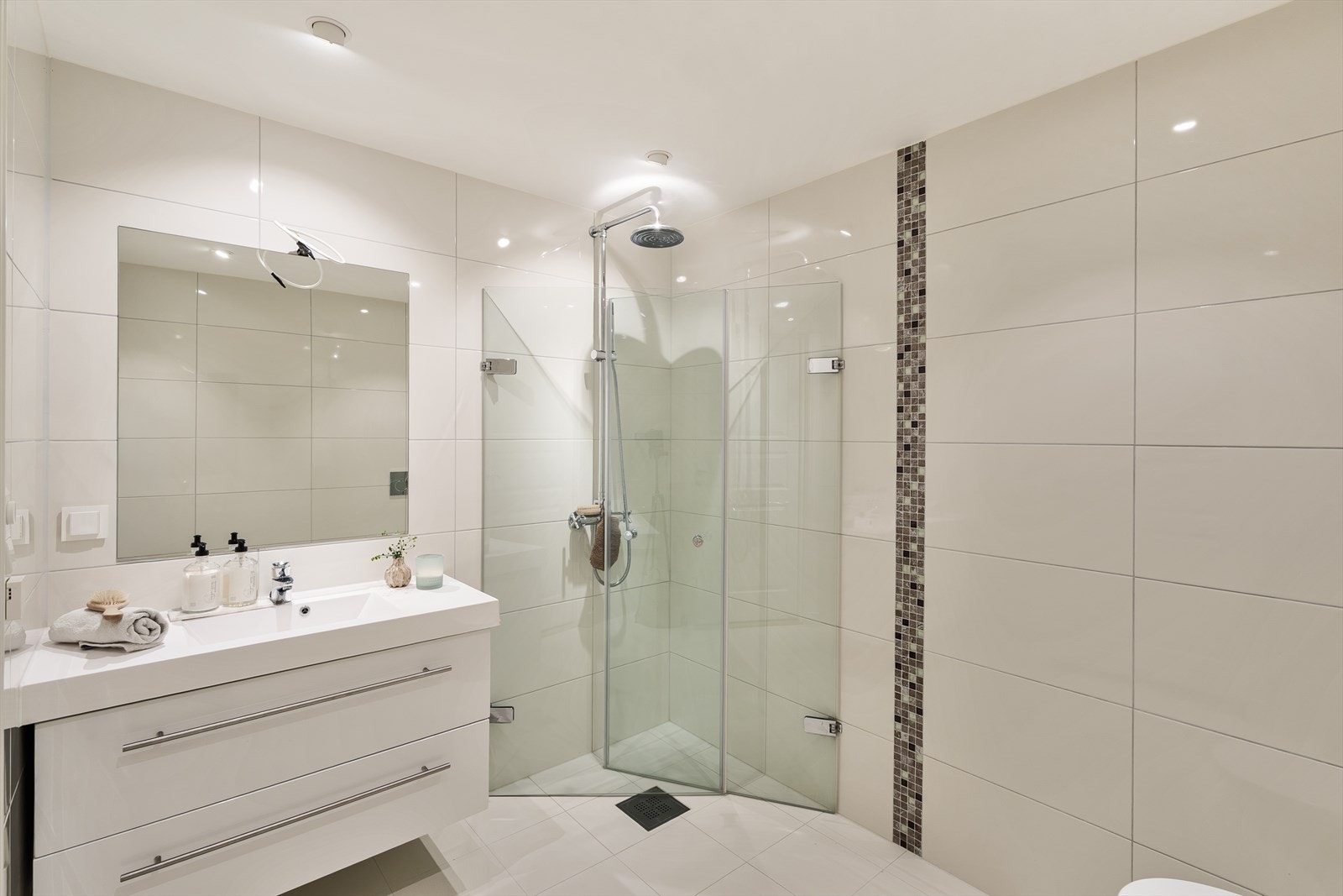 Baderommet har keramiske fliser på gulv og vegger, som gir et stilrent uttrykk og er enkelt å vedlikeholde. Galleribilde