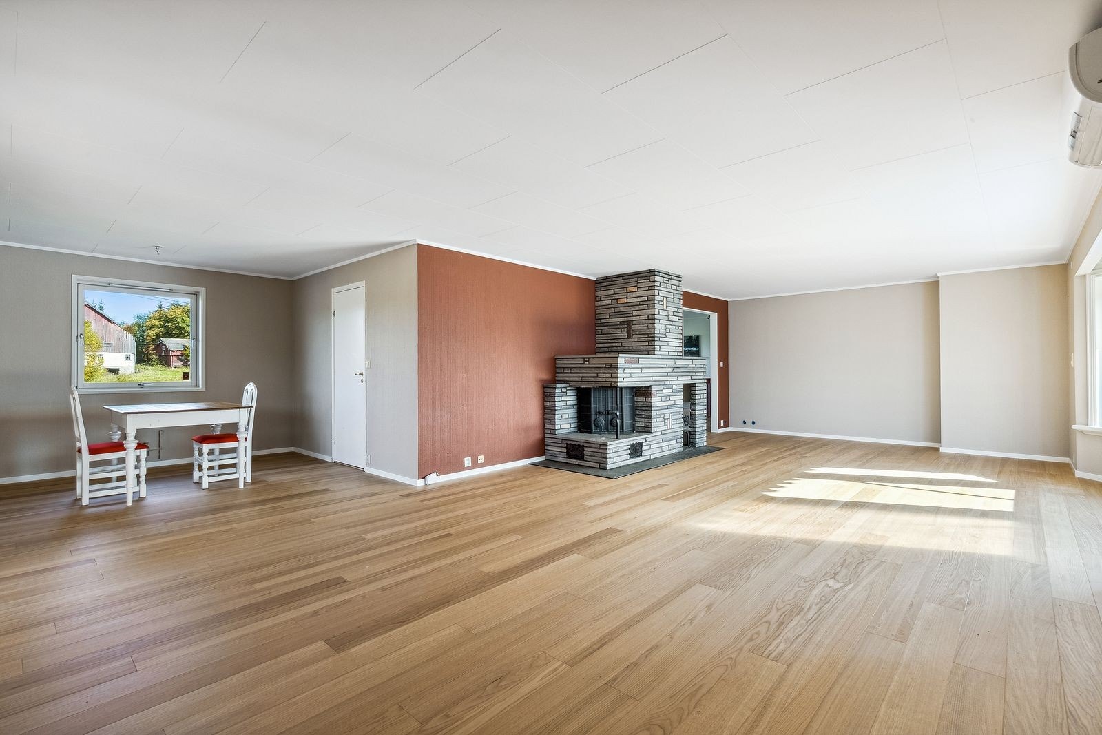 Stue/spisestue med store vindusflate og peis. Galleribilde