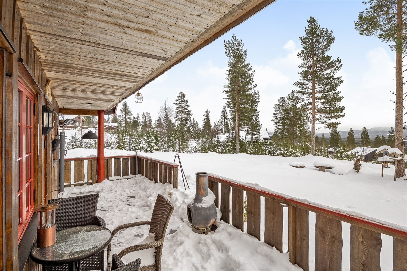 Terrassen som er overbygget har terrassebord på gulv og rekkverk av villmarkspanel. Det er også montert uttrekkbar levegg og utebelysning. Galleribilde
