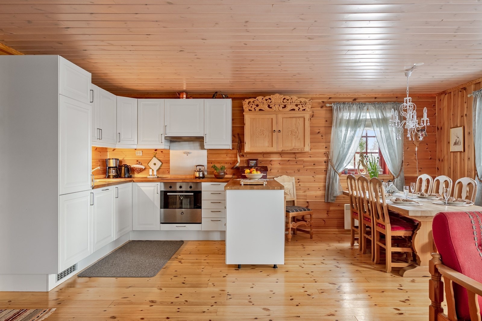 Kjøkkenet har en praktisk utforming med en halvøy mot spisestuen som sørger for ekstra god skap- og benkeplass. Galleribilde