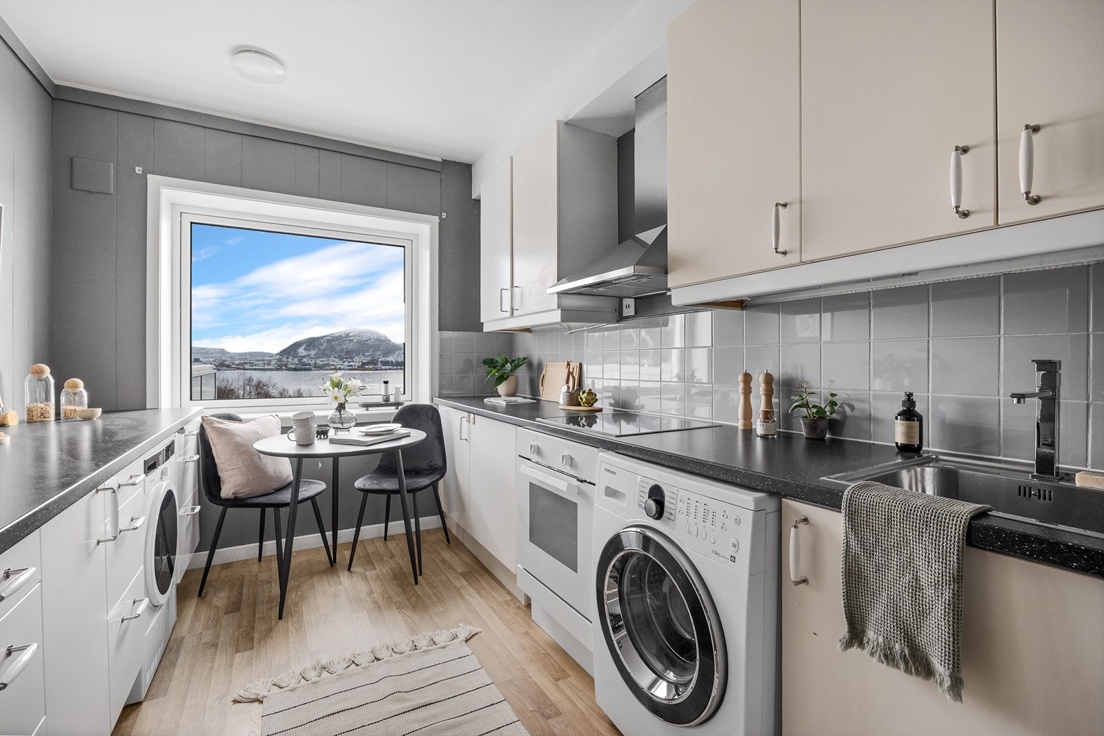 Kjøkkenet har slette fronter og laminat benkeplate, stålvask, oppvaskmaskin, tørketrommel, platetopp og komfyr. Galleribilde