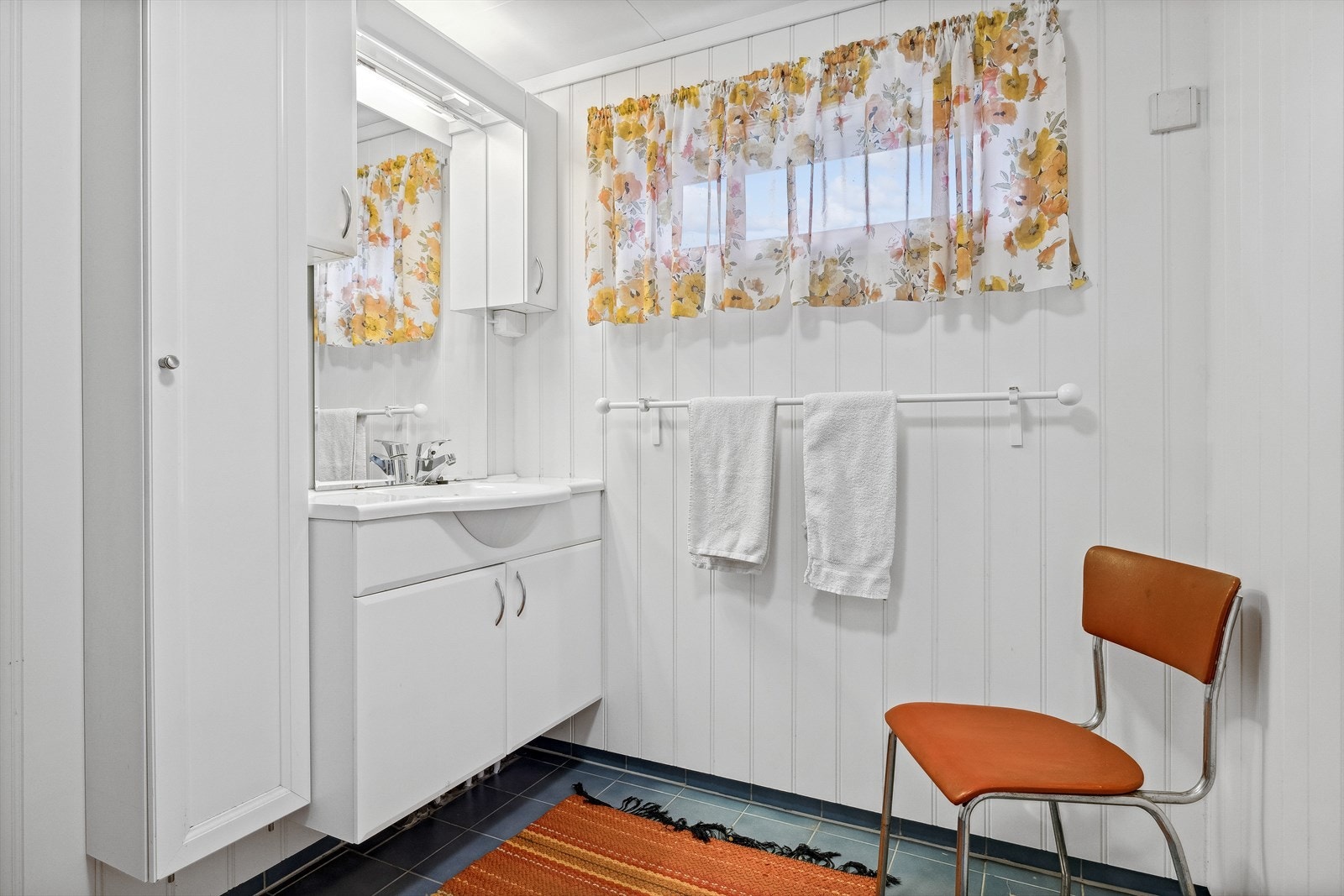 Badet i 1. etasje inneholder heldekkende servant med underskap, overskap med lys, speil, vegghengt høyskap og dusjkabinett. Galleribilde