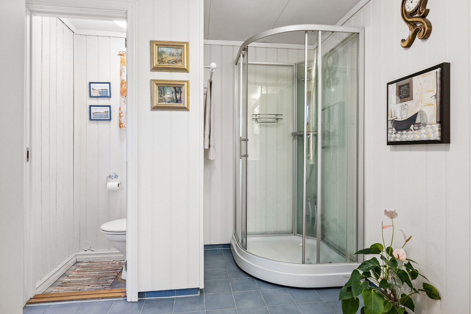 Tilliggende toalettrom har gulvmontert toalett og overflater med belegg på gulv, panelplater på vegg og takess i himling. Galleribilde