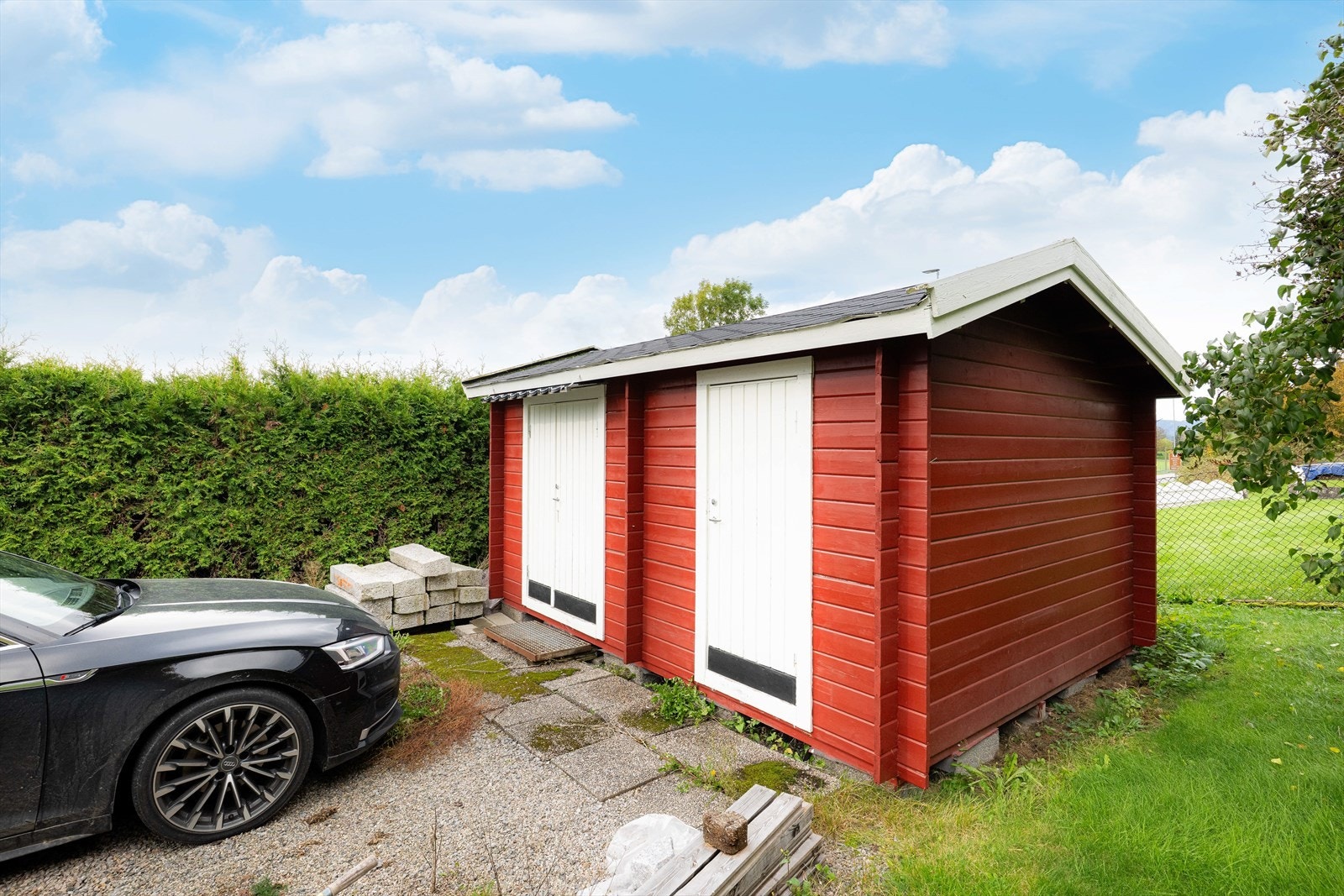 Tomten/e er ligger i skrående terreng og er opparbeidet med plen, prydbusker og trær. Innkjørselen er pent opparbeidet med grus og tujahekk på to sider, hvor det er parkeringsmuligheter foran boligen samt foran bod. Galleribilde