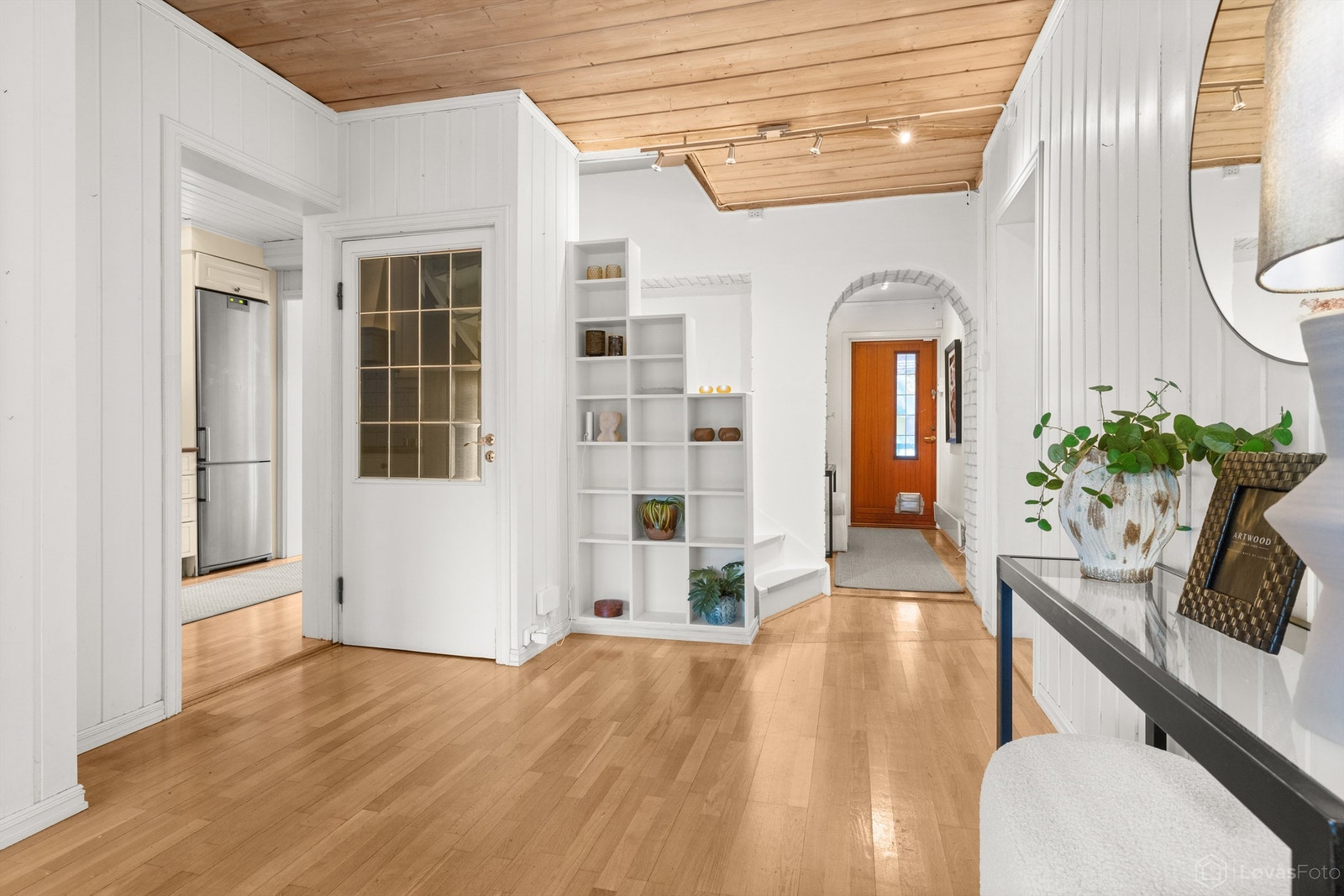 Fra entréen ledes du inn i boligens sosiale sone, med parkett på gulv og panel i himling. Galleribilde