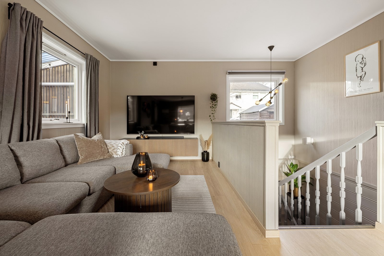 Sofagruppen er naturlig plassert i den åpne stueavdelingen. Her er det god plass til en romslig sofa med tilhørende møbler, og sonen fungerer perfekt som et avslappende samlingspunkt for både rolige hverdagskvelder og hyggelige besøk. Galleribilde