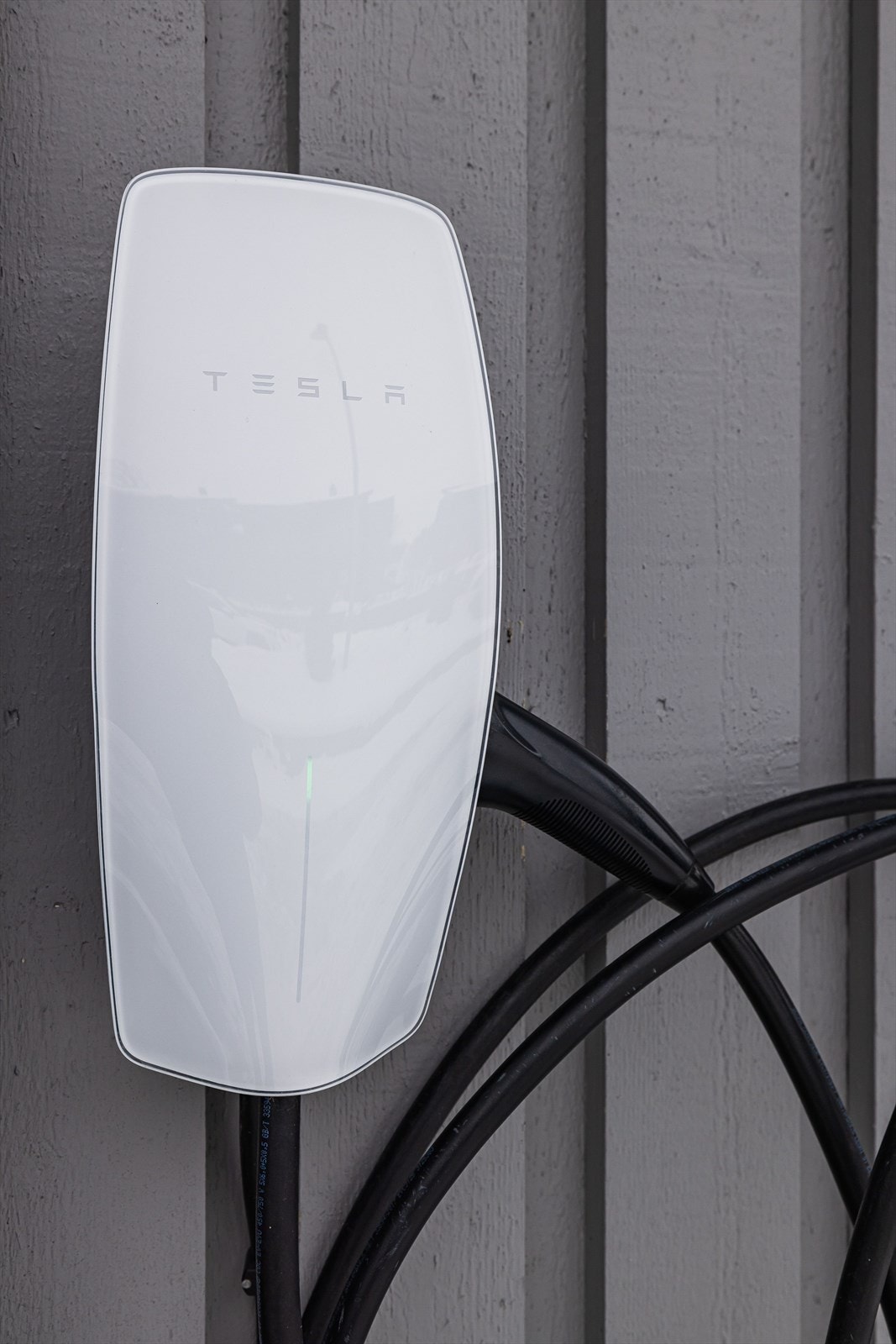 Det er montert elbil-lader fra Tesla på husveggen. Galleribilde