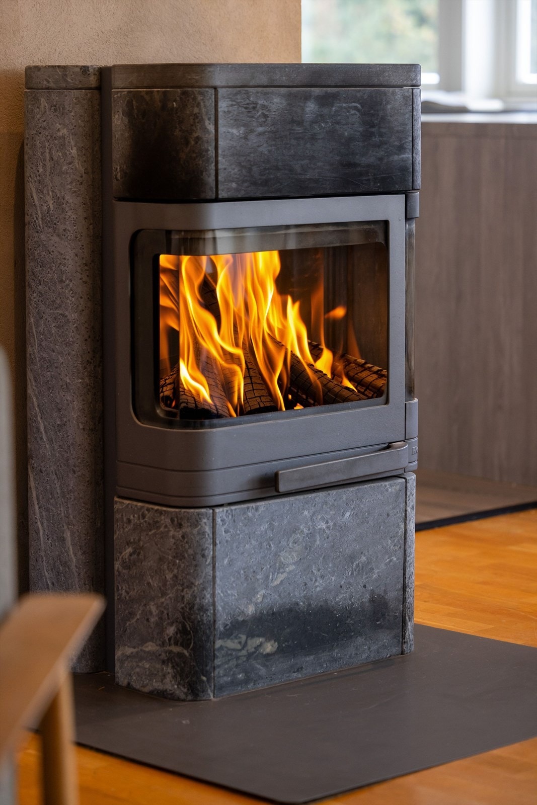 Som et fint midtpunkt i stuen er det en flott klebersteinsovn fra 2006 som både holder godt på varmen og bidrar til ekstra hygge. Galleribilde