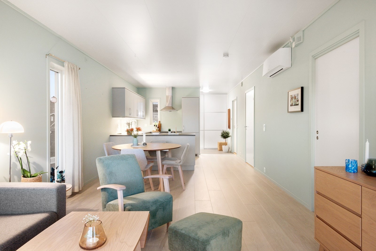 Leiligheten har lyse, behagelige fargetoner som gjør seg godt mot enstavet parkett som man ser her i stue og kjøkken. Galleribilde