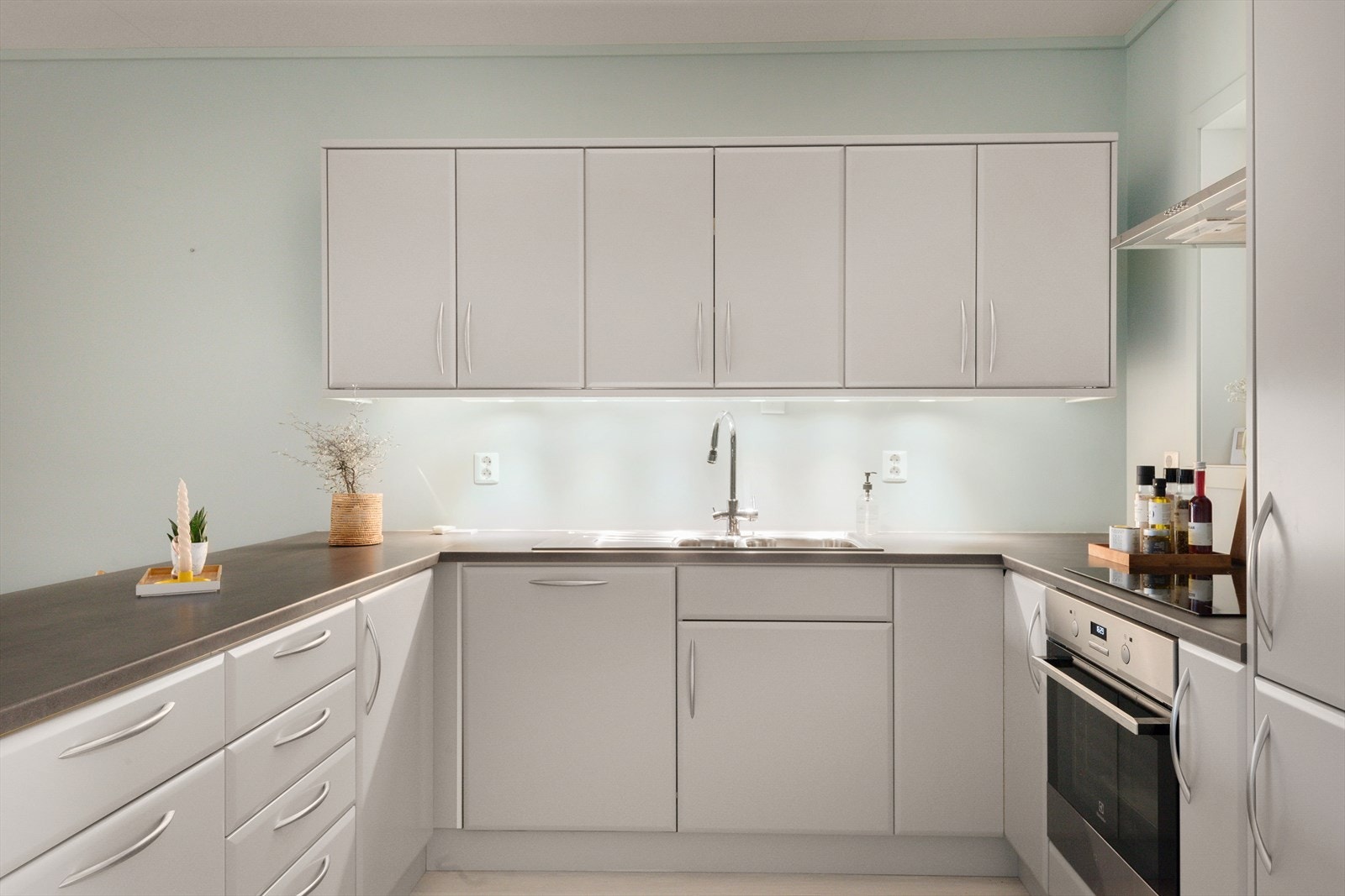 Kjøkkeninnredningen er godt utnyttet med mye skap, og god benkeplass. Karusell nede i det ene hjørnet. Hvitevarer i kjøkkenet er integrerte i innredningen medfølger i handelen. Galleribilde