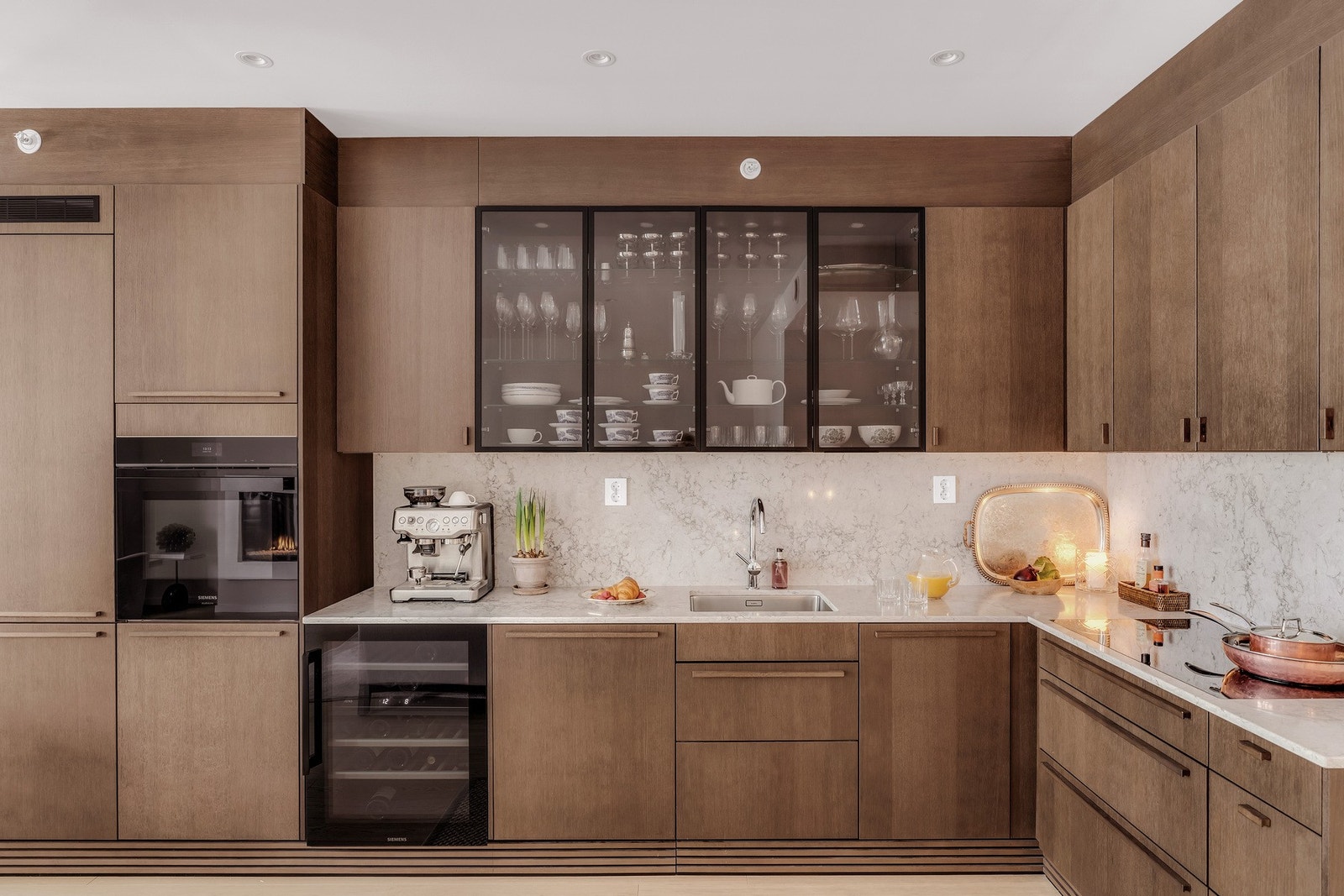 Videre har kjøkkenet benkeplate i kvartkompositt, som også er lagt mellom over- og underskap. Hvitevarepakken er levert av Siemens studio line og består av b.la platetopp m. induksjon, stekeovn, kjøl/frys og oppvaskmaskin. Galleribilde