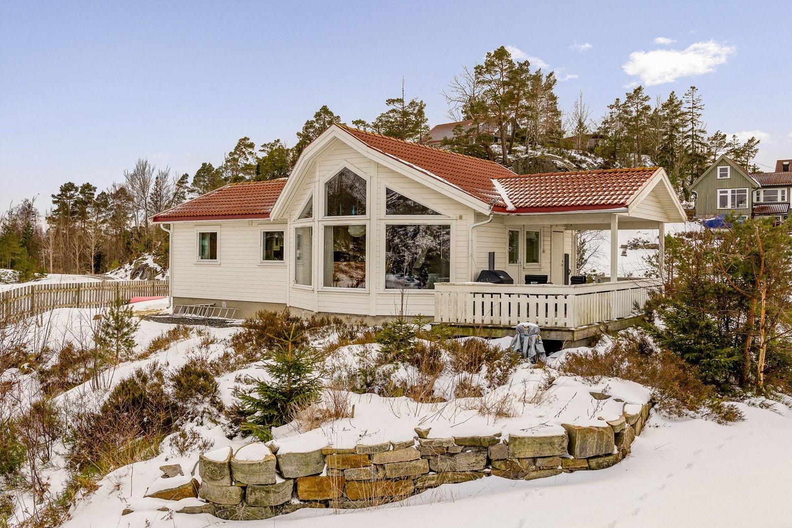 Hytta har store vinduer som slipper inn riklig med naturlig lys Galleribilde