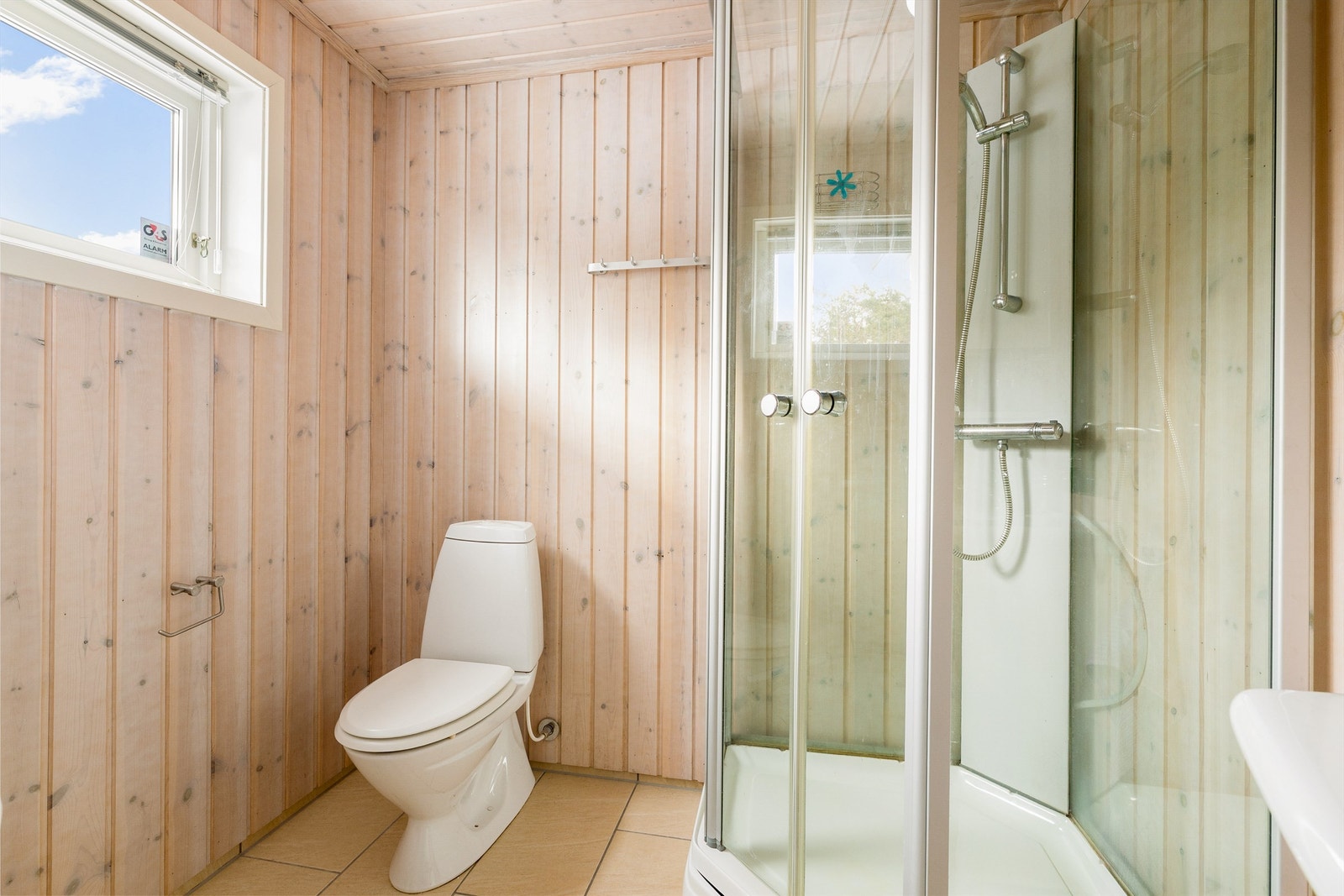 Bad med dusjkabinett, wc, servant i seksjon og opplegg til vaskemaskin og tørketrommel. Galleribilde