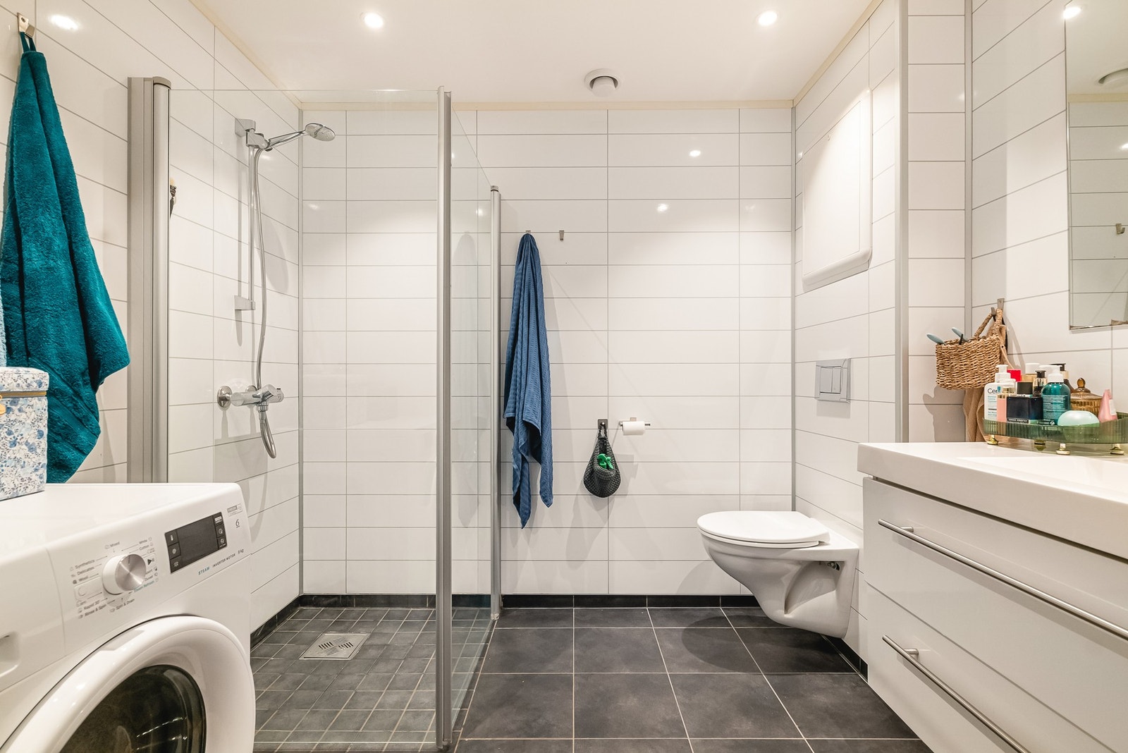 Baderom på 5 kvm med flis på gulv, baderomsplater på vegger og malt platekledning i himling med downlights. Galleribilde