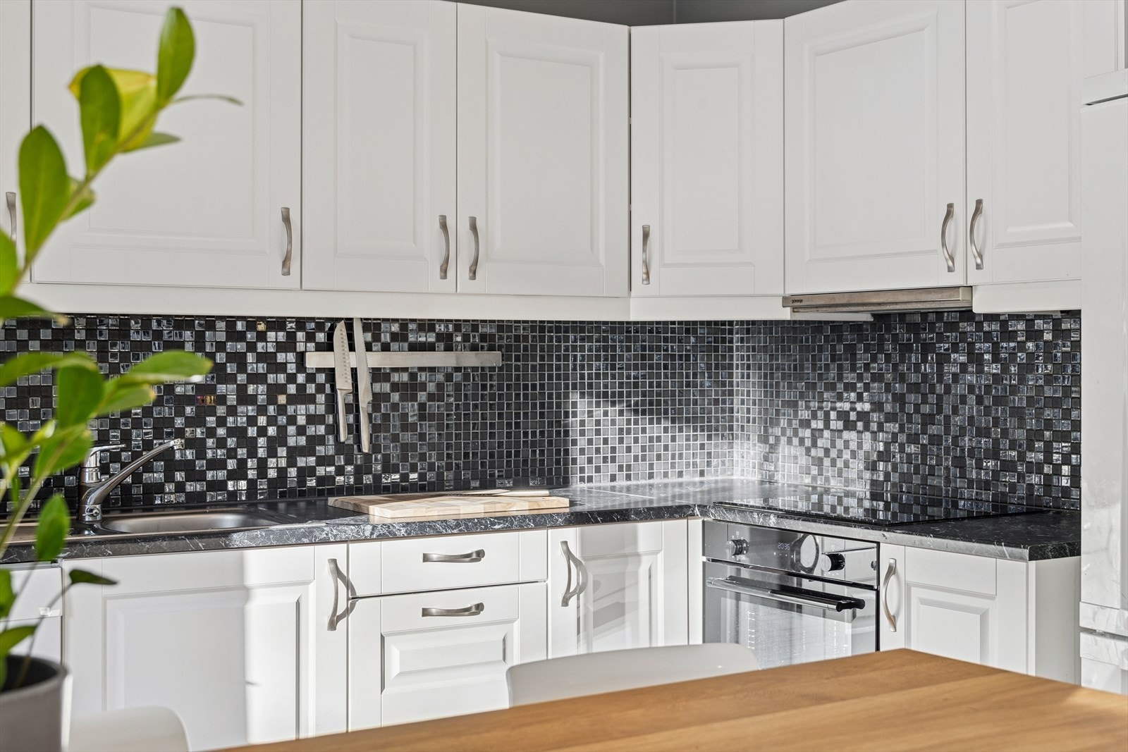 Profilerte og hvite fronter med laminert kjøkkenbenk. Her har du godt med benk- og skapplass Galleribilde