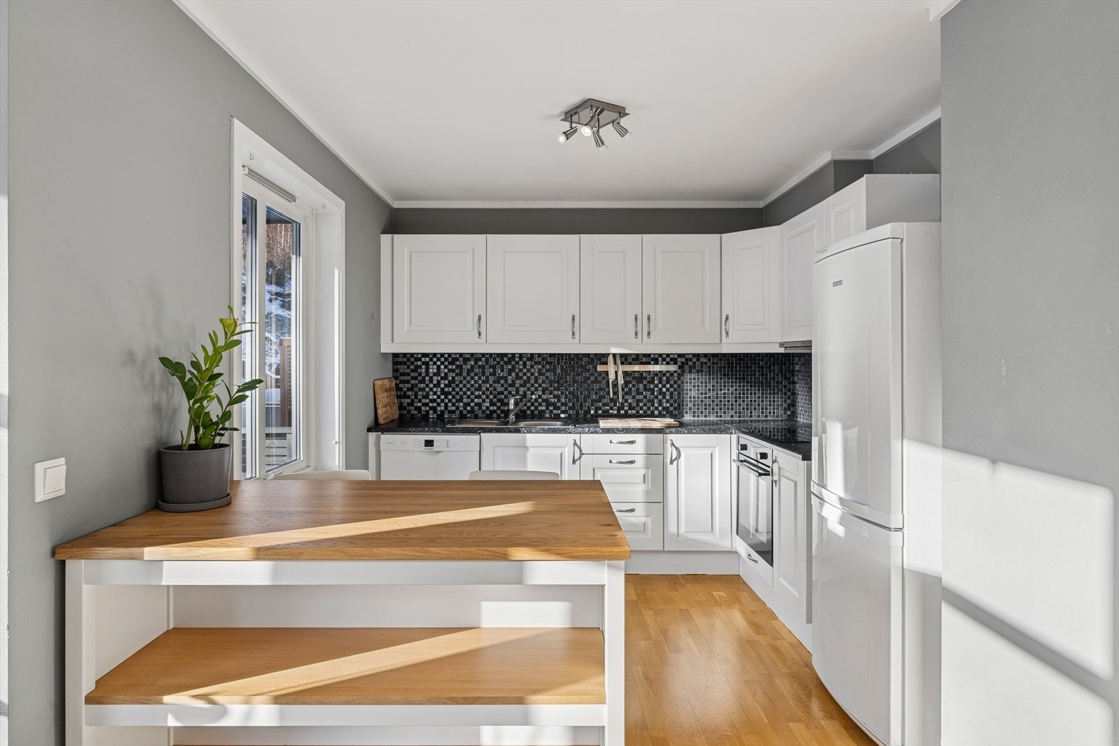 Kjøkkenet er utstyrt med hvitevarer som stekeovn, platetopp, oppvaskmaskin og kjøleskap med frys. Galleribilde