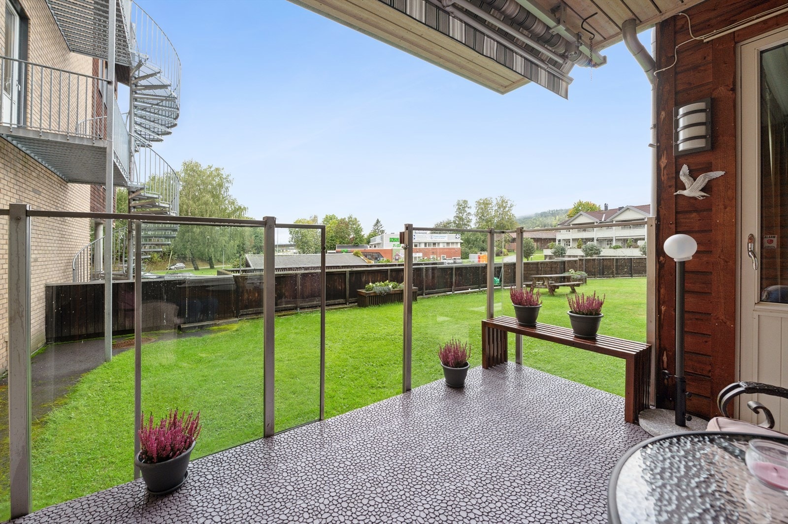 Utsikt til fellesareal som er pent opparbeidet med plen og beplantning. Galleribilde