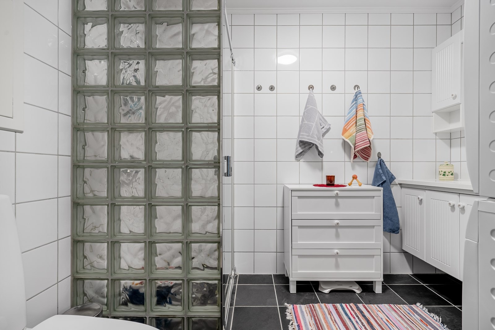 Badet inneholder dusj, toalett, vaskemaskin, tørketrommel og baderomsservant Galleribilde