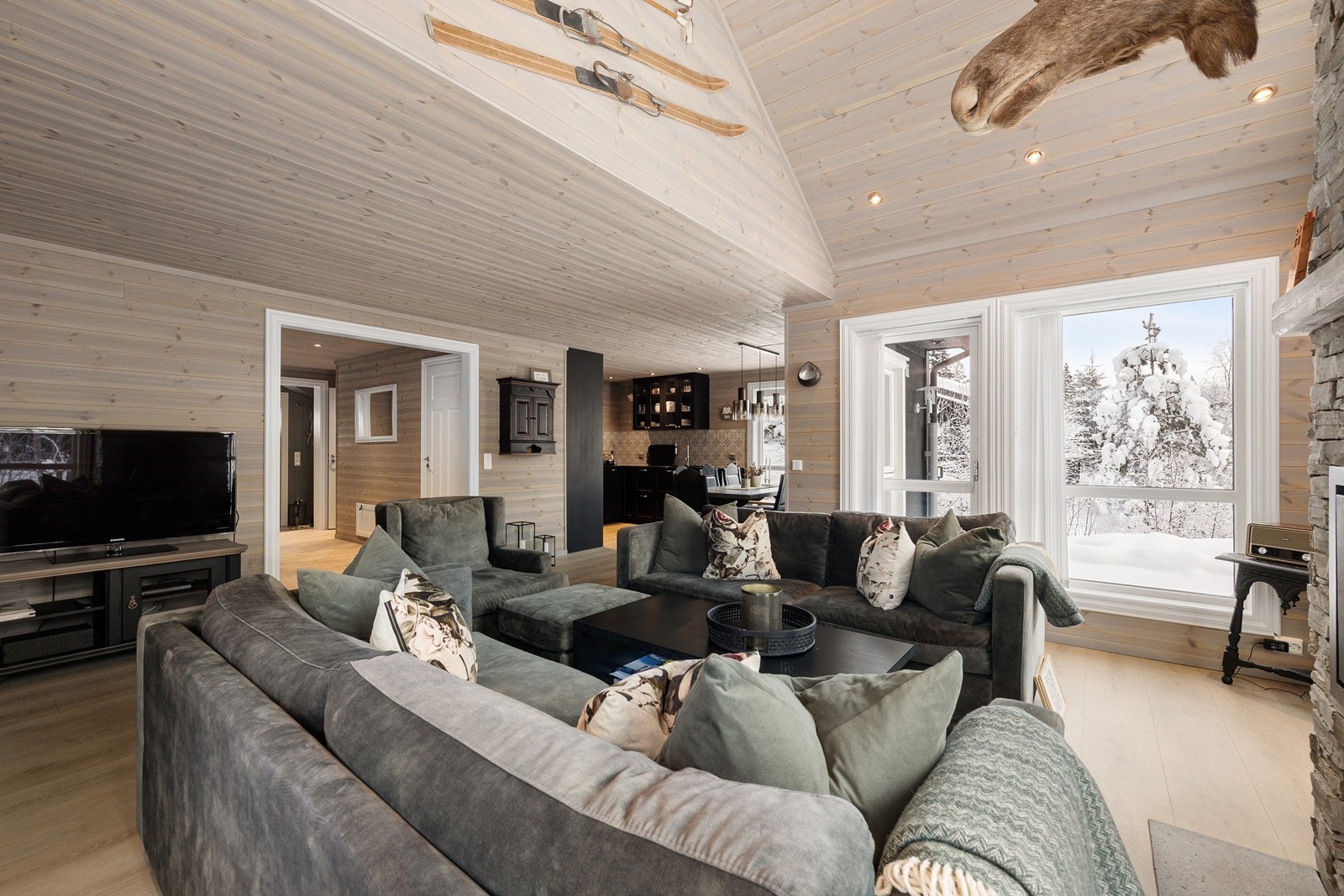 Stuen er romslig, og åpner opp for ulike møbleringsalternativer med en stor og komfortabel sofakrok, underholdningsavdeling og lenestoler, der en kan sitte å nyte en god bok. Galleribilde