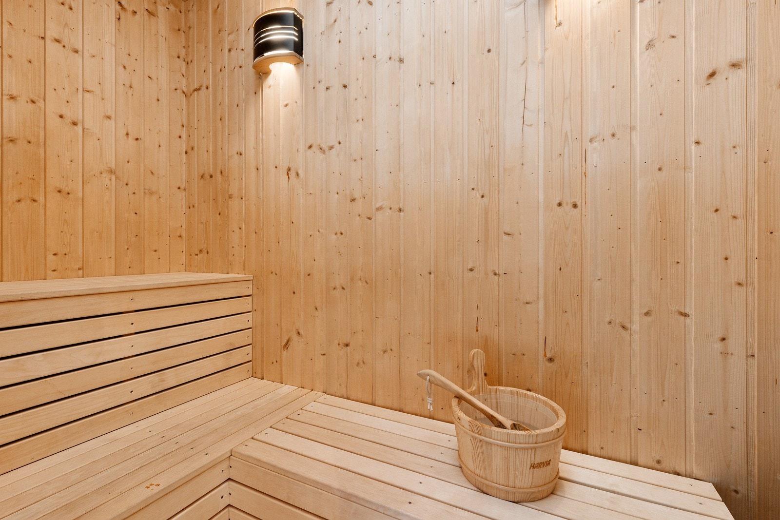 Tilstøtende badstue med elektrisk badstuovn og plassbygde sittebenker. Galleribilde