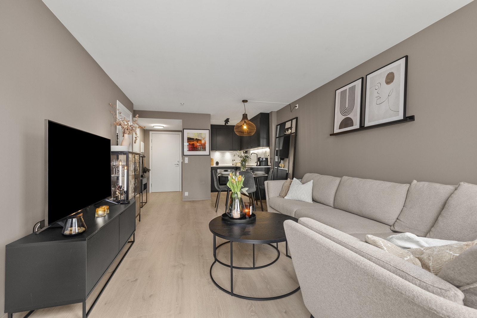 Den åpne løsningen mellom stue og kjøkken skaper en sosial og innbydende sone. Galleribilde