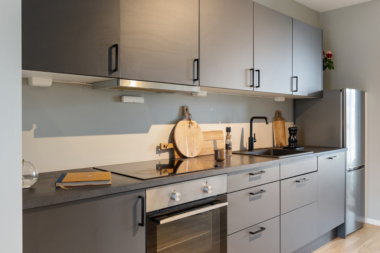 Integrerte hvitevarer som platetopp, oppvaskmaskin og komfyr, gir en ryddig kjøkkenløsning. Galleribilde