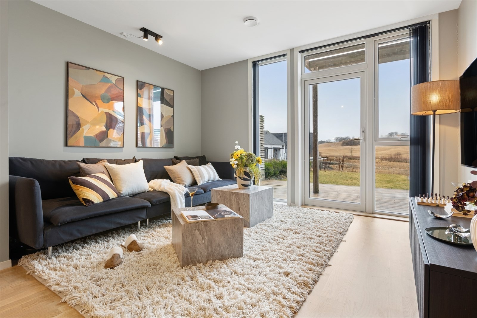 Stuen har store vindusflater som vender mot fin utsikt og uteplass utenfor. Galleribilde