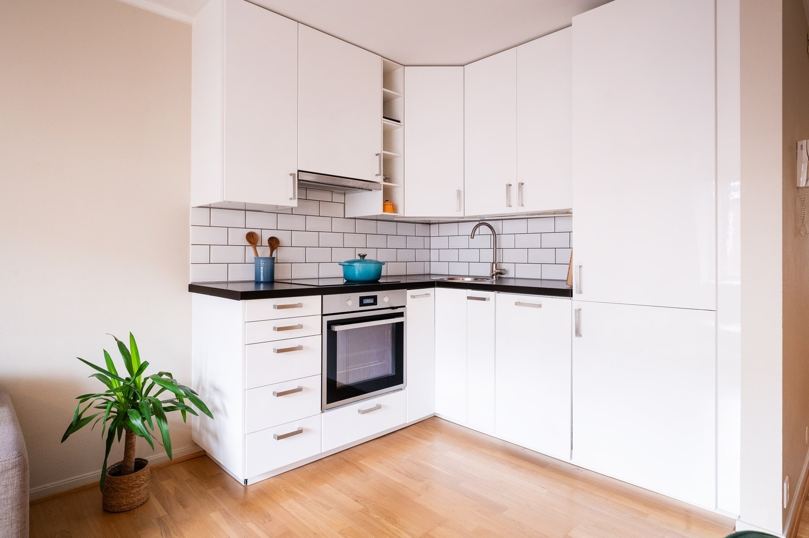 Åpen stue kjøkken løsning med et tidløst og pent kjøkken fra 2015. Her er det integrerte hvitevarer og bra med skap og benkeplass Galleribilde