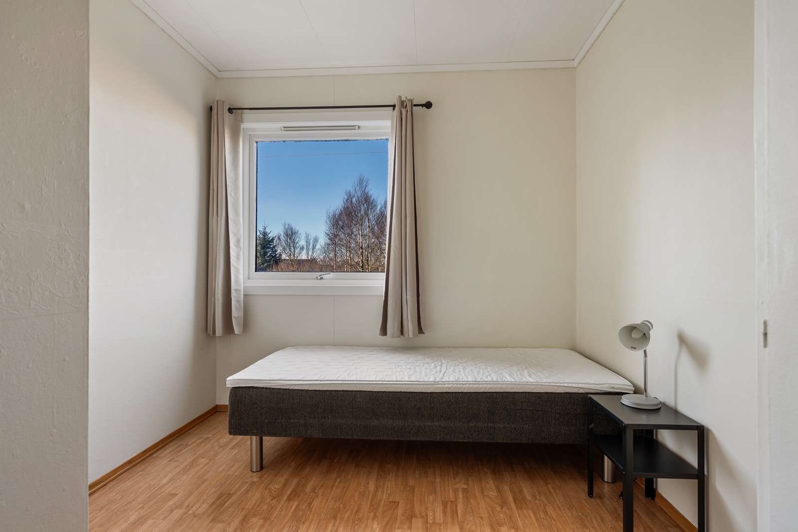 Soverom med dobbelt innebygget skap med to småskap over. Belegg på gulv og tapetserte vegger. Galleribilde