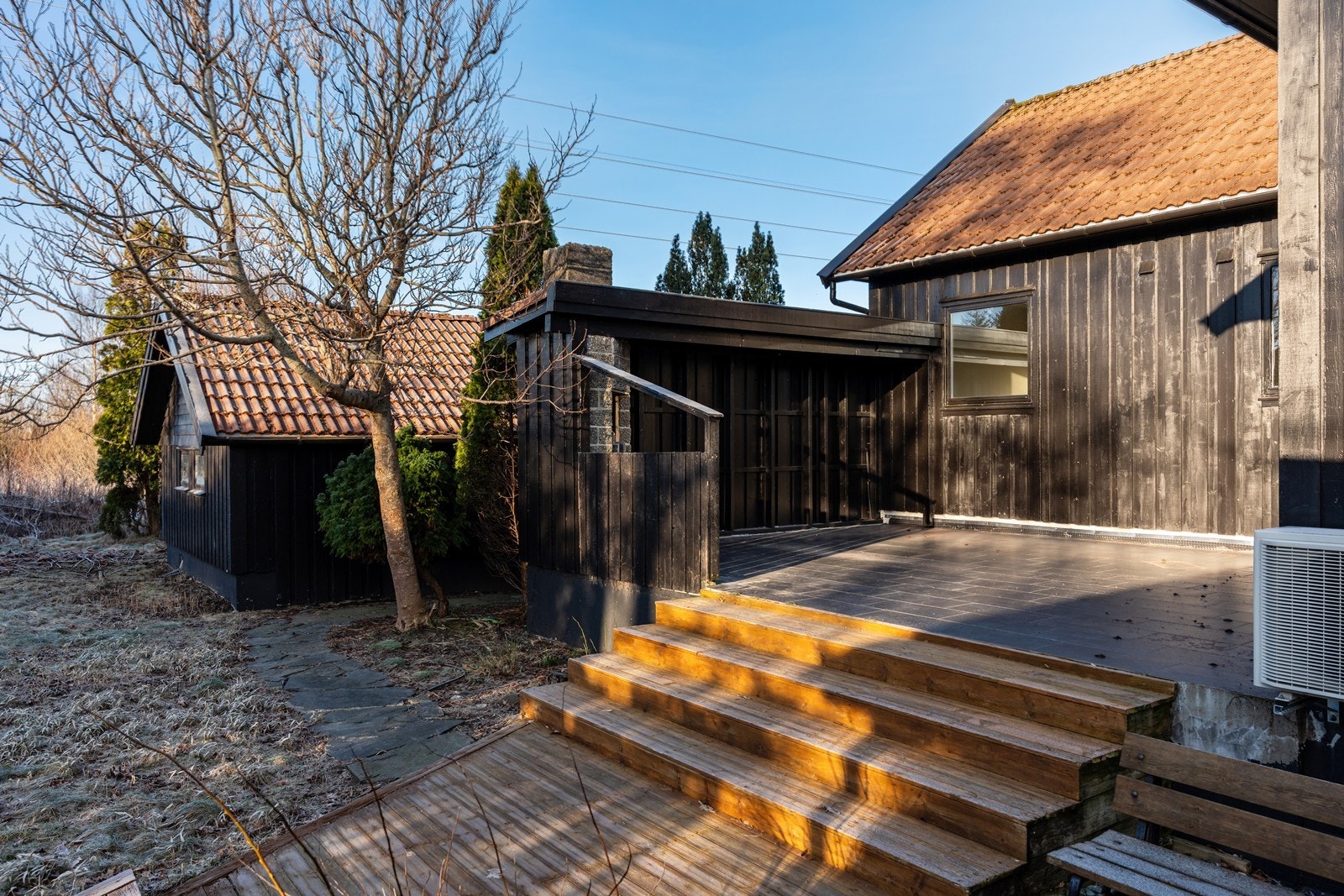 Terrassen har brei og god trapp ned til hagen Galleribilde